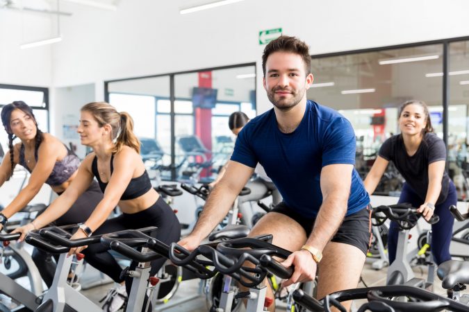 A spin class with members sat on the spin bikes