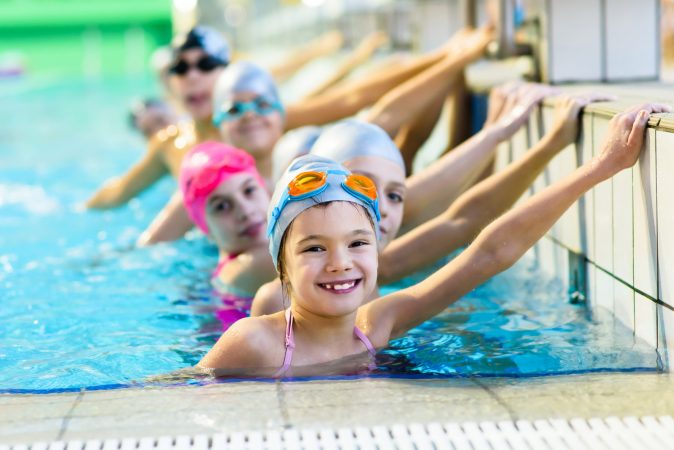 Children at the end of a lane partaking in a swimming lesson