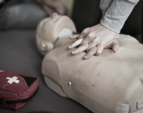 Person administering chest compressions on a CPR manakin